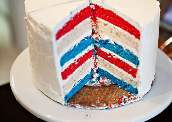 A clean white cake with subtle layered detail, photographed in soft daylight on a simple surface, conveying understated elegance